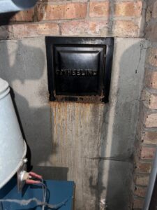 Ash pit cleanout showing water leakage - chimney water damage repair in Chicago suburbs