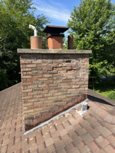 Damaged chimney before rebuild - deteriorated brick and mortar needing restoration in Chicagoland