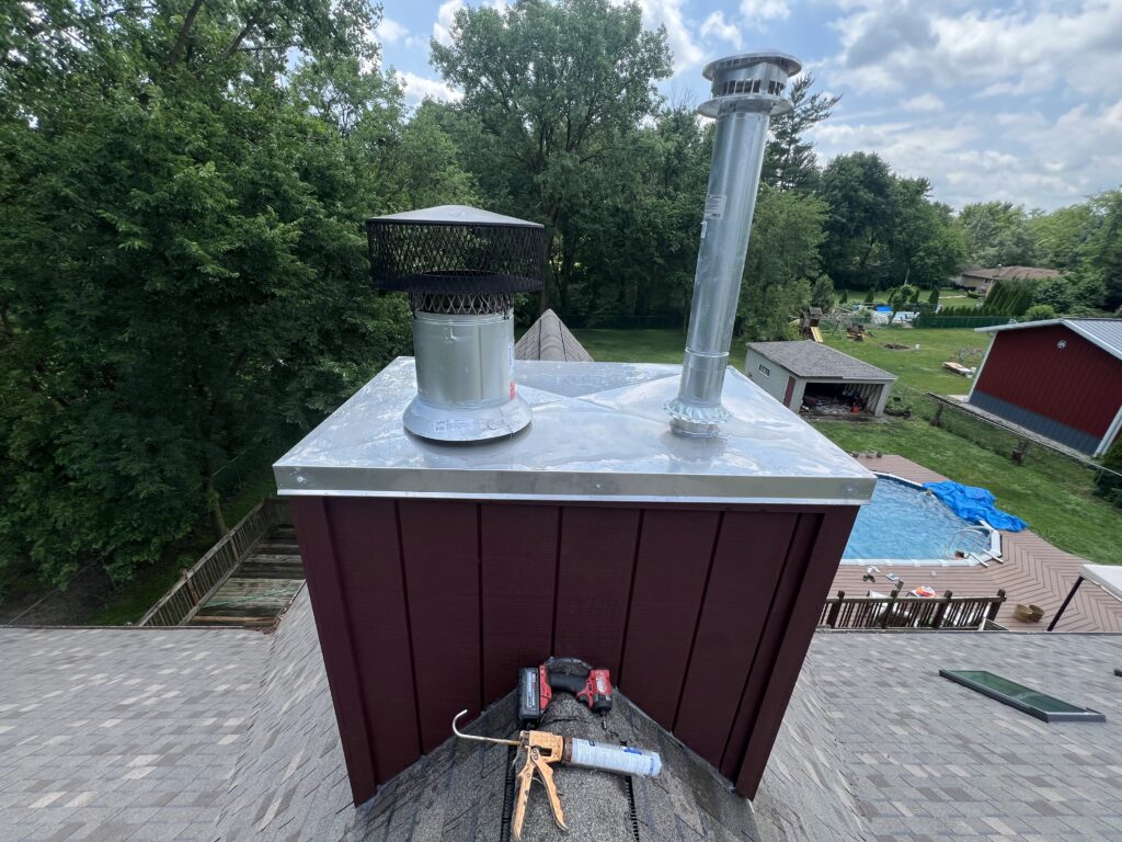 Chimney chase top with rain covers and siding on chimney structure - cap and cover inspection in Chicagoland