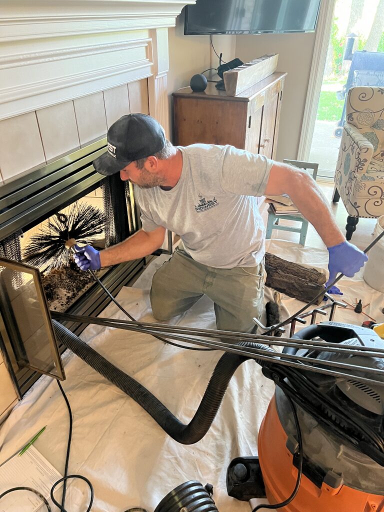 Professional chimney cleaning in progress - CSIA-certified chimney sweep by Midwest Chimney Specialists