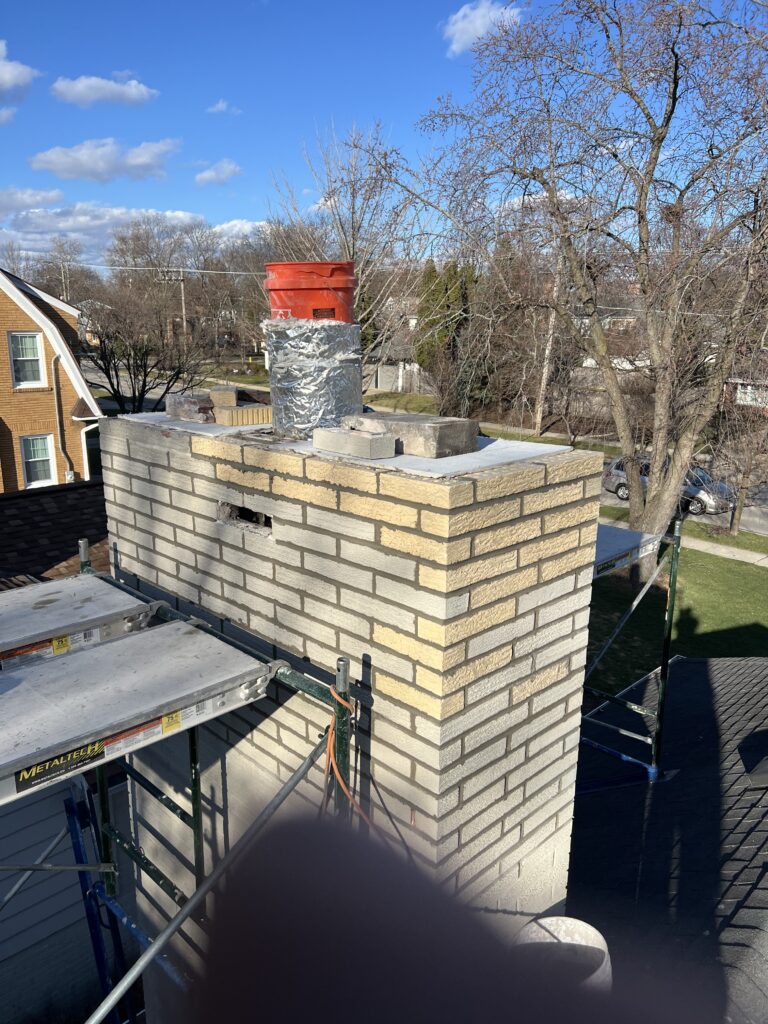Chimney crown pour in progress during brick replacement - masonry repair service in Chicagoland