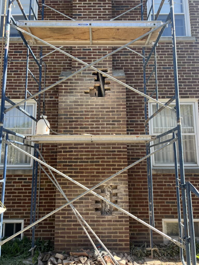 Furnace liner installation in progress through brick replacement access holes - chimney relining in Chicago suburbs
