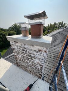 Chimney repairs completed with stainless steel rain covers and new crown pour - masonry restoration after in Chicago, IL
