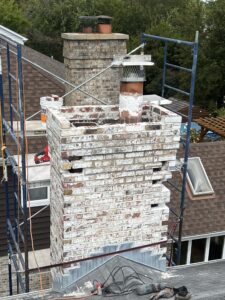 Chimney before brick replacement and new crown installation - masonry repair assessment in Chicagoland