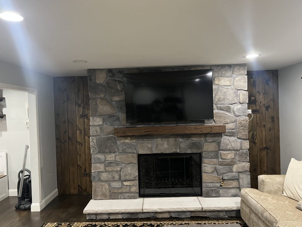 Prefab fireplace installation with cultured stone surround and custom mantel - fireplace install in Chicagoland